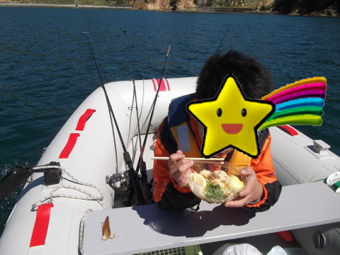 ボートの上で冷やしうどんを食べる息子